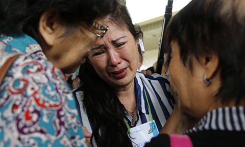 Relatives of passengers onboard AirAsia flight QZ8501 cry in a waiting area at Juanda International Airport in Surabaya